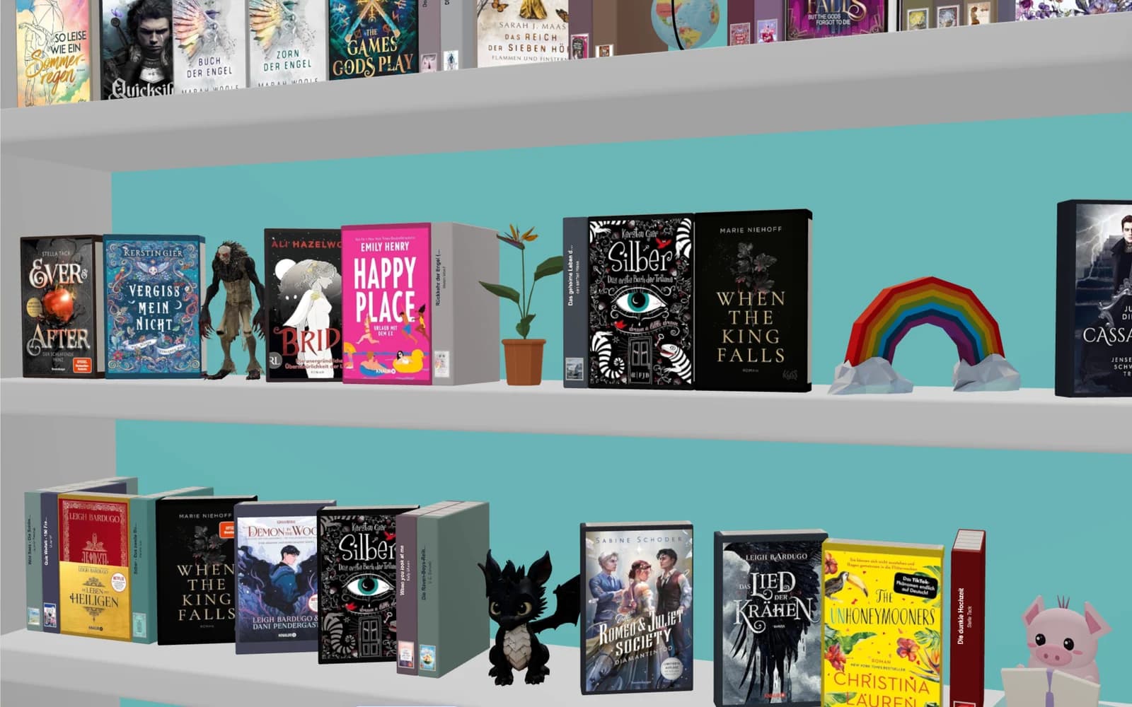 Geschmücktes Regal mit Regenbogen, Pflanze und Figuren zwischen den Büchern